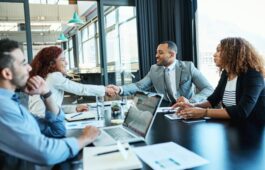 Shot of businesspeople shaking hands during a meeting in an office.