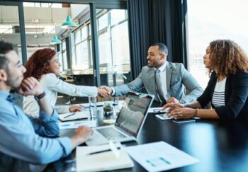 Shot of businesspeople shaking hands during a meeting in an office.