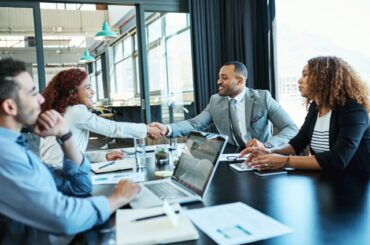 Shot of businesspeople shaking hands during a meeting in an office.